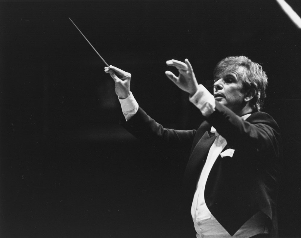 Photograph focused closely on Christoph von Dohnányi. He is conducting, and is in the middle of a cue.