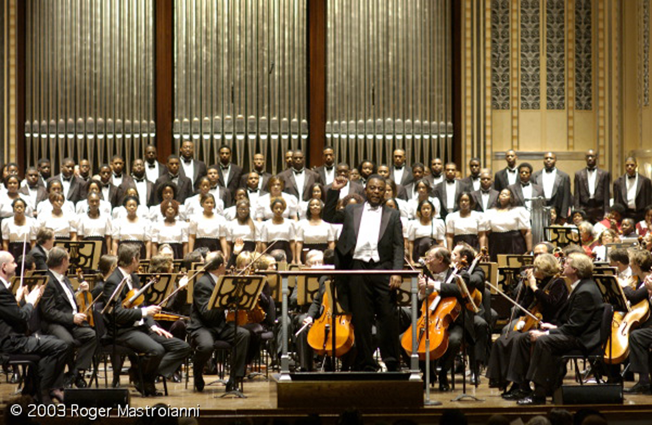 William Henry Caldwell acknowledges applause alongside the choir during the 2003 MLK Concert.