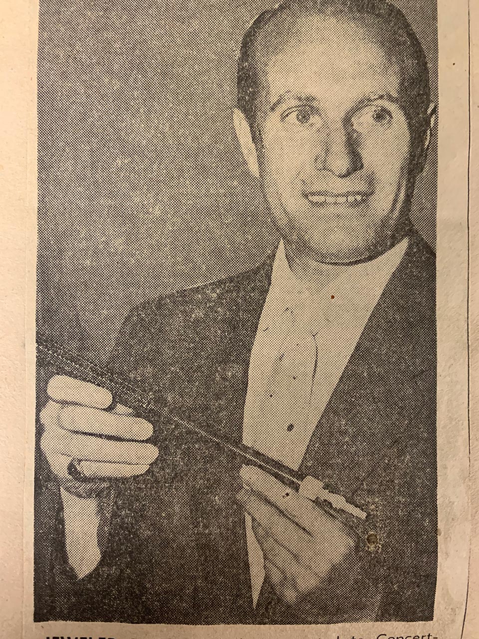 Concertmaster Josef Gingold poses for photographs with the newly received baton.