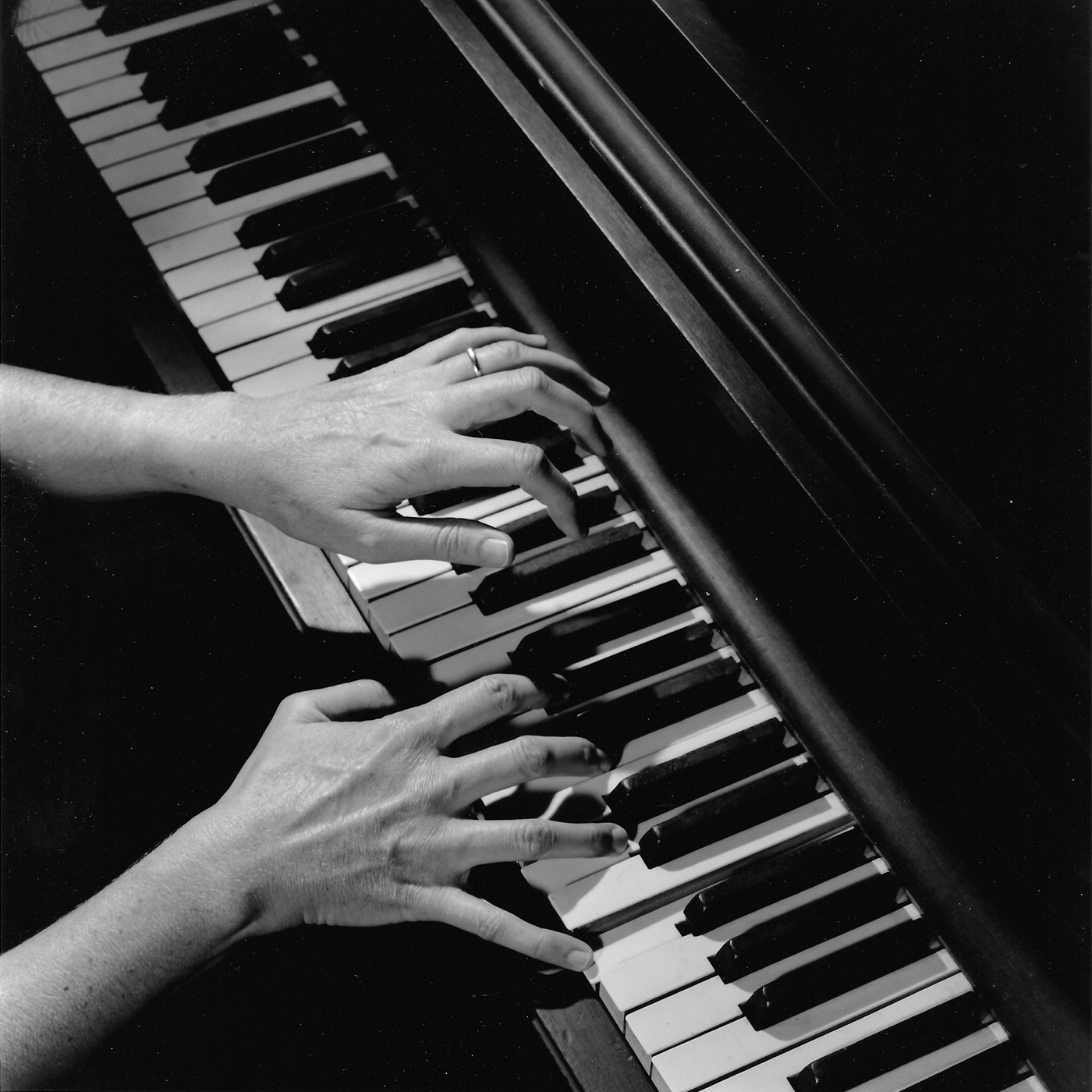 Joela Jones's hands playing the piano from overhead